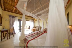 a bedroom with a bed with a mosquito net at Ihamba Lakeside Safari Lodge in Kahendero