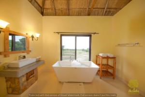 a large bathroom with a large tub and a window at Ihamba Lakeside Safari Lodge in Kahendero