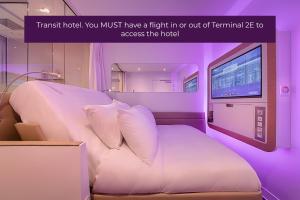 a hotel room with a bed and a television at YOTELAIR Paris CDG - Transit Hotel - Terminal 2E in Roissy-en-France