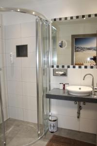 a bathroom with a shower and a sink at Der Sailer Hotel & Restaurant in Obertauern