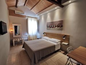 een slaapkamer met een bed, een tafel en een raam bij B&B Re Umberto in Milazzo