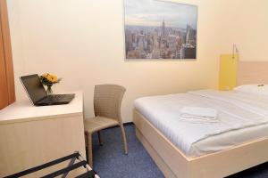 a hotel room with a bed and a laptop on a desk at Best Deal Airporthotel Weeze in Weeze