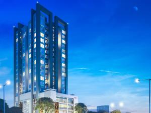 een weergave van een hoog gebouw met lichten aan bij Indigo Heights Hotel & Suites in Lahore