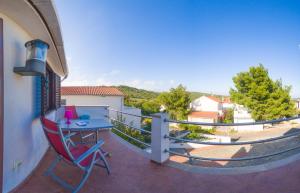 a balcony with a table and a chair on it at The Sea House Apartments in Vis