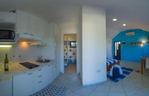 a kitchen with white cabinets and a blue refrigerator at The Sea House Apartments in Vis