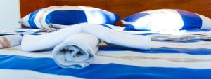 a bed with blue and white blankets and pillows at The Sea House Apartments in Vis