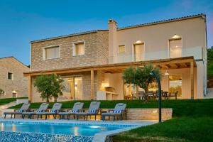 a house with a swimming pool in front of a house at Motovun Villas in Motovun
