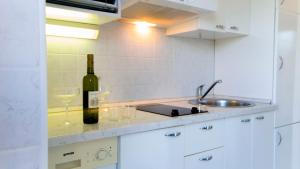 a bottle of wine and glasses on a kitchen counter at The Sea House Apartments in Vis