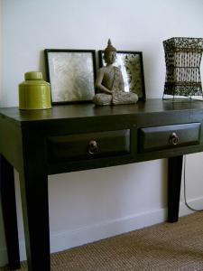 a black table with a statue sitting on top of it at La Villa Camille in La Creche