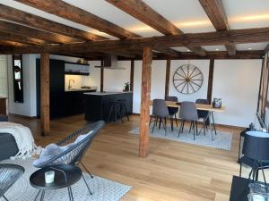 a living room with a table and chairs and a kitchen at Løðupakkhúsið - LPH - Mid Floor in Sørvágur