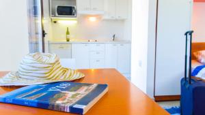 a hat sitting on top of a table with a book at The Sea House Apartments in Vis