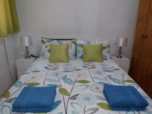 uma cama com duas almofadas azuis em cima em Entire Senglea Seaview Town house em Senglea