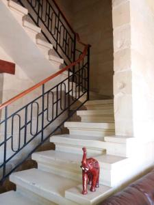 a small red toy elephant sitting on the stairs at Entire Senglea Seaview Town house in Senglea