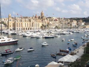 a bunch of boats in a harbor with a city at Entire Senglea Seaview Town house in Senglea