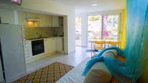 a kitchen and living room with a couch and a table at The Sea House Apartments in Vis