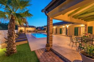 a house with a swimming pool and a palm tree at Villa Idassa in Bri&scaron;evo