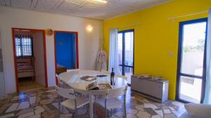 a living room with a table and chairs and yellow walls at The Sea House Apartments in Vis