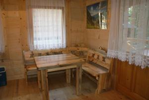 a room with a table and benches in a cabin at Ostoja Karlików - Domki do Wynajęcia in Bukowsko