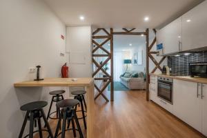 une cuisine avec un comptoir et des tabourets dans une pièce dans l'établissement Beautiful Downtown Apartment, à Lisbonne