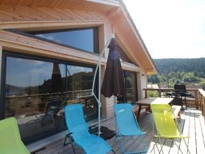 a deck with a table and chairs and an umbrella at l'Edelweiss in Gérardmer