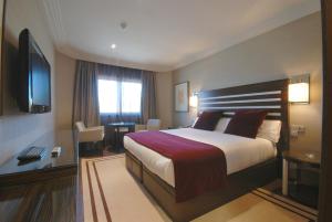 a hotel room with a bed and a television at Hotel Los Peñascales - Adults Only in Las Rozas de Madrid
