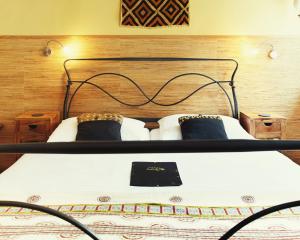 a bed with a black headboard and two pillows at Bed & Breakfast SahaRa in Lüneburg