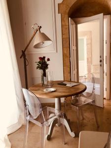 a dining room table with chairs and a lamp at Le Stanze di Carlo in Siracusa