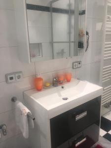 a bathroom with a white sink and a mirror at Ferienhaus Gumann in Nuremberg +49 photos