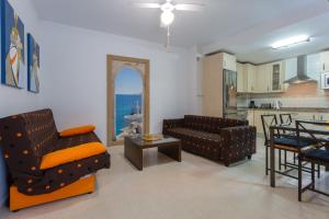 ein Wohnzimmer mit 2 Sofas und einer Küche in der Unterkunft Puerta San FELIX free parking by Cadiz4Rentals in Cádiz