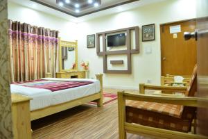 1 dormitorio con 1 cama y TV en una habitación en Alaf Laila Guest House en Abbottābād