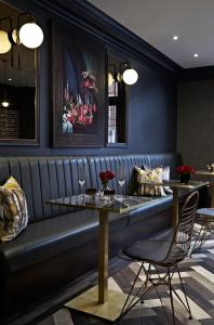 ein Esszimmer mit einer Bank und 2 Tischen in der Unterkunft The House of Toby in London