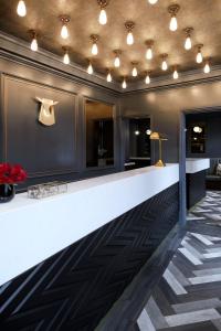 a lobby with a white counter and a wall with lights at The House of Toby in London