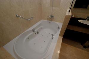 a white bath tub in a bathroom with a sink at Hotel Los Peñascales - Adults Only in Las Rozas de Madrid