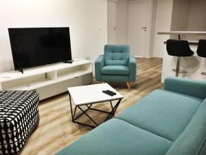 Televízia a/alebo spoločenská miestnosť v ubytovaní Apartamenty Zajezdnia MTP