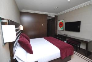 Dormitorio con cama, escritorio y TV en Hotel Los Peñascales - Adults Only en Las Rozas de Madrid