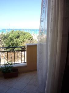 a room with a balcony with a view of the beach at Brezza Marina in San Vito lo Capo