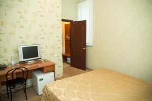 1 Schlafzimmer mit 2 Betten und einem Schreibtisch mit einem Computer. in der Unterkunft Europa in Uljanowsk