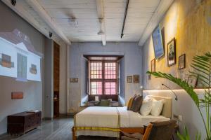 a bedroom with a large bed and a window at The Postcard Mandalay Hall, Kochi in Cochin
