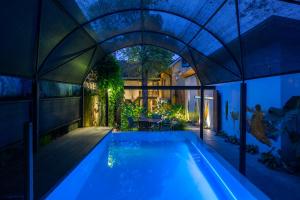 una piscina cubierta en una casa por la noche en The Postcard Mandalay Hall, Kochi, en Kochi
