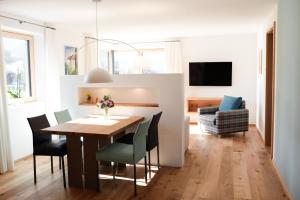 a dining room and living room with a table and chairs at Haus FreiRaum in Fischen
