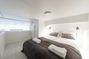 a bedroom with a large bed with two towels on it at Spot Apartments Tikkurila in Vantaa