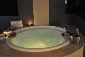 a large bath tub with candles in a bathroom at Hotel Los Peñascales - Adults Only in Las Rozas de Madrid +24 photos