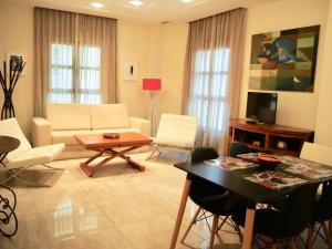 salon z białymi meblami i stołem w obiekcie Apartamento con encanto en el Barrio de Santa Cruz w Sewilli