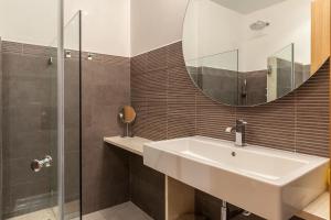 łazienka z umywalką i lustrem w obiekcie Apartamento con encanto en el Barrio de Santa Cruz w Sewilli
