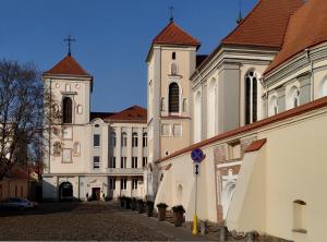 um grupo de edifícios com uma igreja e uma torre em Villa Kaunensis em Kaunas