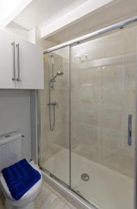 bagno con doccia, servizi igienici e asciugamano blu di Les Salins de Batz-sur-mer a Batz-sur-Mer Altre 27 foto