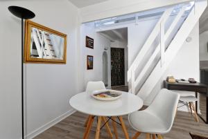 een witte eetkamer met een witte tafel en witte stoelen bij Les Salins de Batz-sur-mer in Batz-sur-Mer