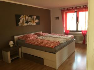 a bedroom with a bed with red curtains at Ferienhaus Burggraf in Zermüllen