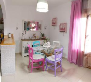 a kitchen with a table and purple chairs in a kitchen at CASITA LUAN in Tragacete