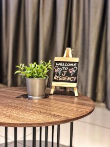 a table with a sign and a potted plant on it at J Residence in Banting